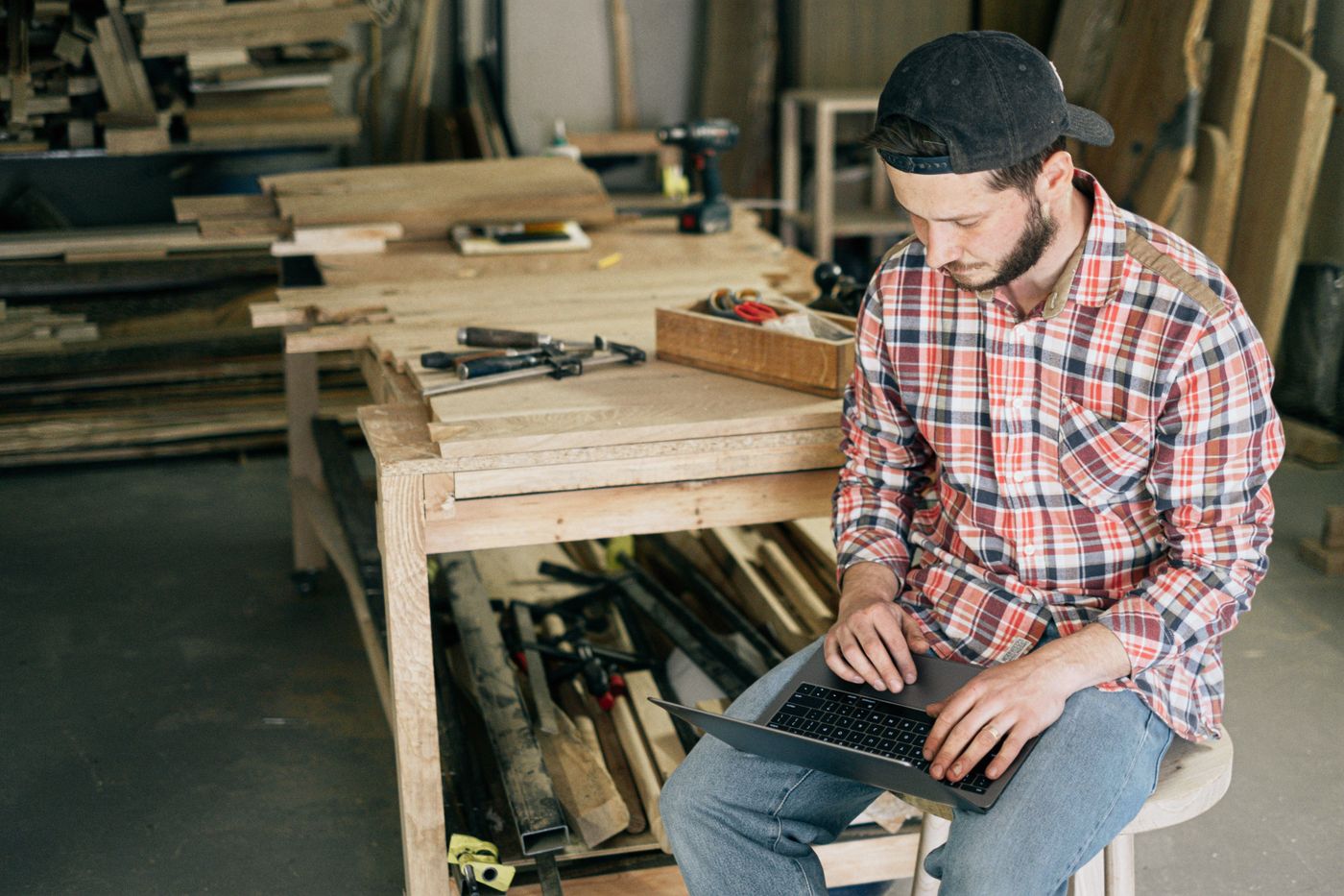 A supplier working on a laptop in a workshop