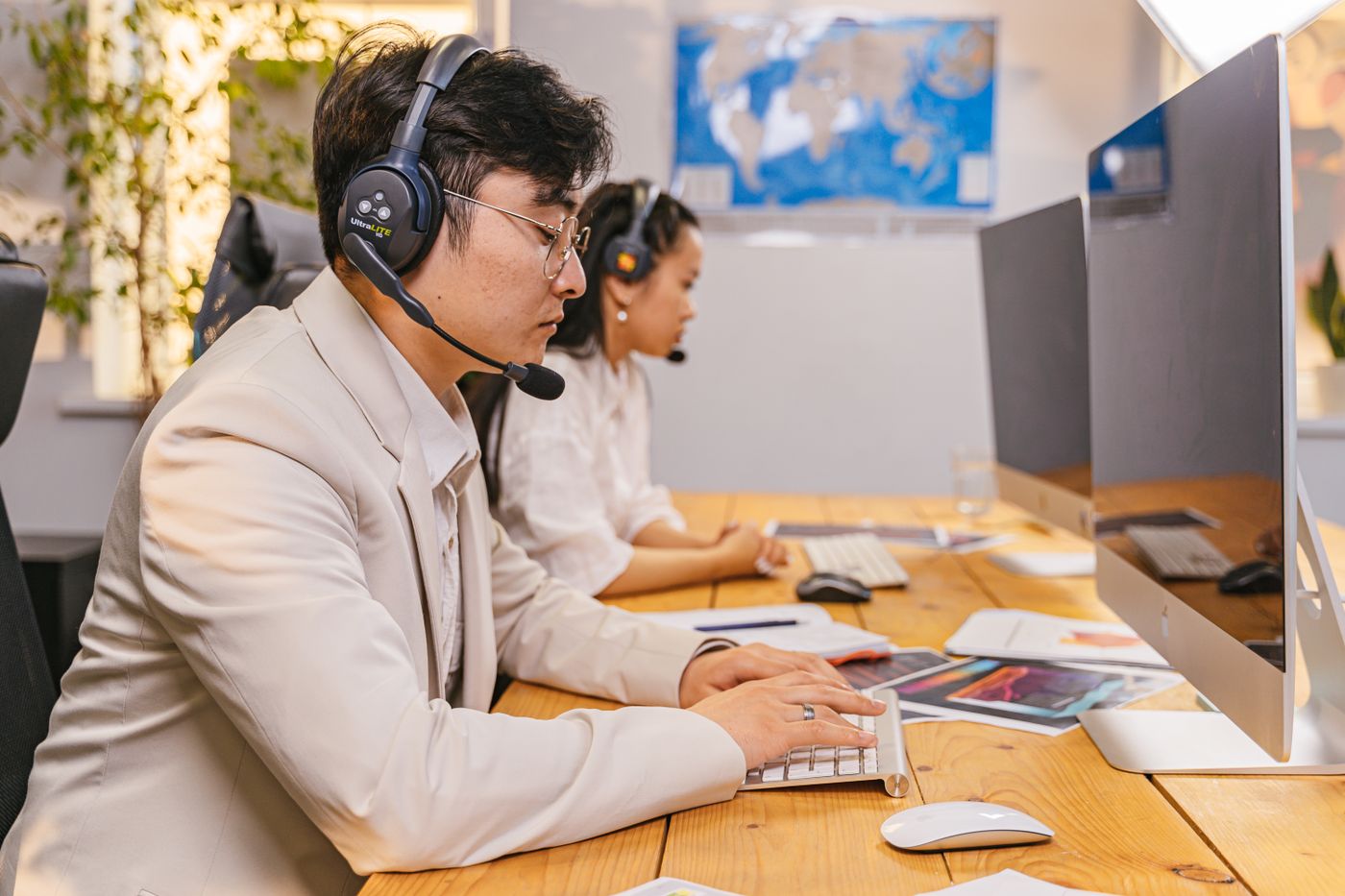 Two members of the team on calls at their desks